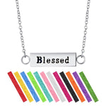 A stainless steel necklace diffuser with a 'Blessed' pendant on a chain, accompanied by vibrant colored refill pads.